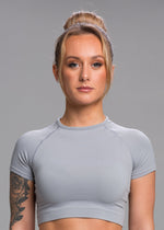 A model wears the Sassy Sportswear Crop Top Timeless in the Marble Grey color