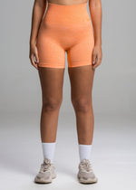 A model wears the Sassy Sportswear Shorts Sexyback in the Orange Flame color