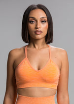 A model wears the Sassy Sportswear Sports Bra Sexyback in the Orange Flame color